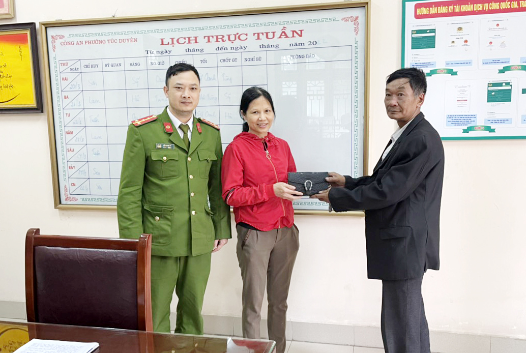 Ông Đặng Đình Bính trao trả lại tài sản cho chị Phạm Thị Nga tại trụ sở Công an phường Túc Duyên.