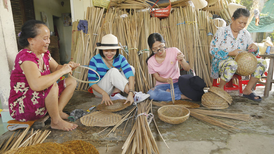 Du khách trải nghiệm nghề đan lát tại xã Hòa Tịnh (huyện Mang Thít, tỉnh Vĩnh Long). Ảnh: Linh Tâm