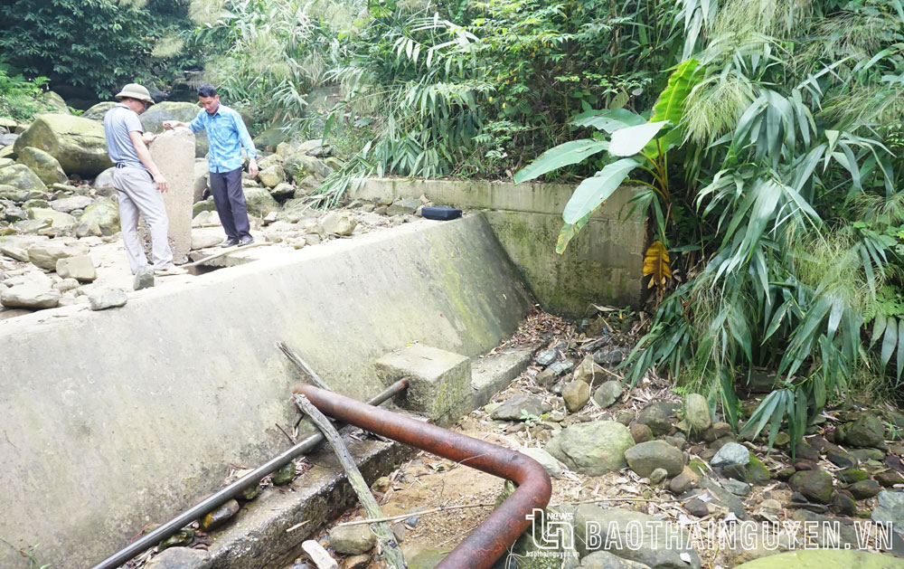 Người dân xóm Khe Đù kiểm tra ống thu nước của công trình hệ thống tưới cây ăn quả tập trung đặt tại khe suối.
