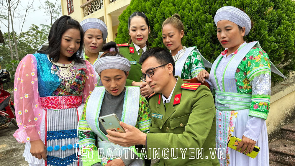 Cán bộ Công an xã Văn Lăng (Đồng Hỷ) hướng dẫn và vận động bà con dân tộc Mông ở xóm Khe Mong đăng ký tài khoản dịch vụ công trực tuyến. Ảnh: T.L
