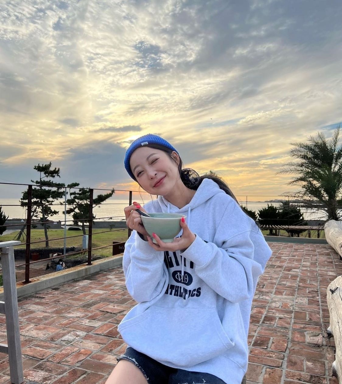 Seo Hye Lin trông thật nhí nhảnh và vui tươi trong trang phục áo hoodie màu xám phối với chân váy, cùng một chiếc mũ len màu xanh.