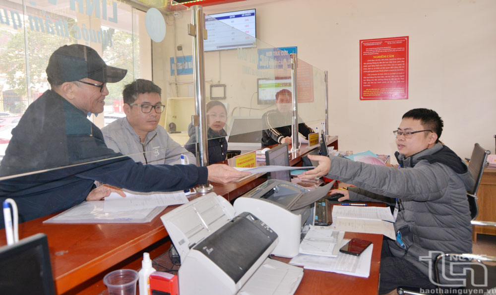 Cán bộ Bộ phận một cửa UBND huyện Đại Từ hướng dẫn người dân sử dụng dịch vụ công trực tuyến để giải quyết thủ tục hành chính.