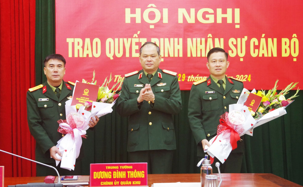  Trung tướng Dương Đình Thông, Chính ủy Quân khu 1, trao quyết định bổ nhiệm chức vụ và tặng hoa chúc mừng Đại tá Trần Ngọc Tiến (bên trái), Thượng tá Ân Trung Tuyến.