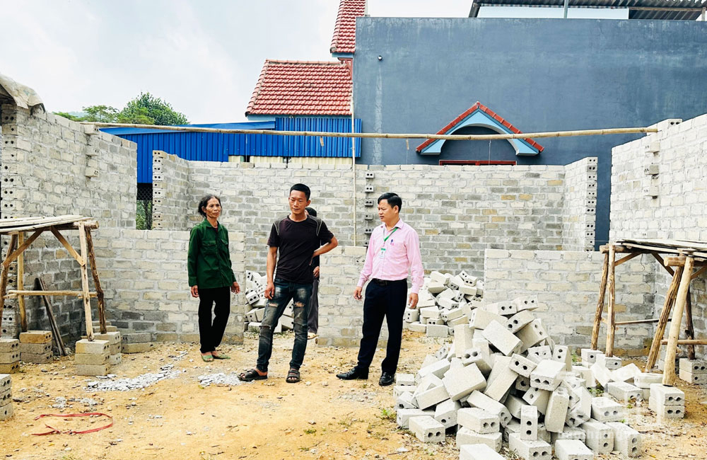Cán bộ NHCSXH huyện Định Hóa đến kiểm tra, thẩm định hiệu quả sử dụng vốn vay để xây nhà của người dân xã Quy Kỳ.