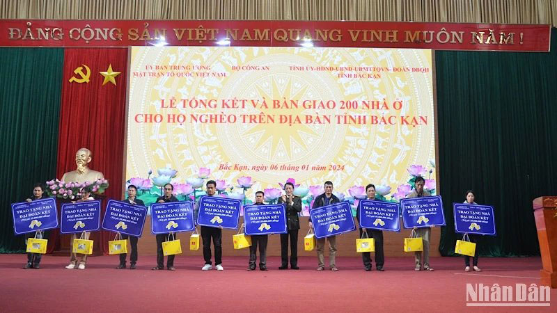 Thượng tướng Lương Tam Quang, Thứ trưởng Bộ Công an, trao chìa khóa tượng trưng cho 10 hộ dân được hỗ trợ nhà. 
