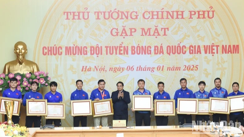 Thủ tướng Phạm Minh Chính trao Bằng khen của Thủ tướng Chính phủ tặng các thành viên Đội tuyển bóng đá nam Quốc gia Việt Nam. (Ảnh: TRẦN HẢI)