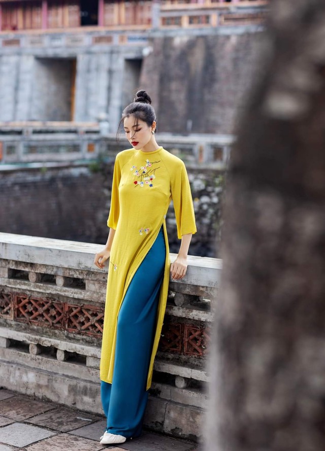 Xu hướng phối đồ đa sắc màu đã tràn ngập vào trong những thiết kế áo dài với màu vàng tươi của tà áo thêu hoa và màu xanh cổ vịt của quần dài lụa satin.