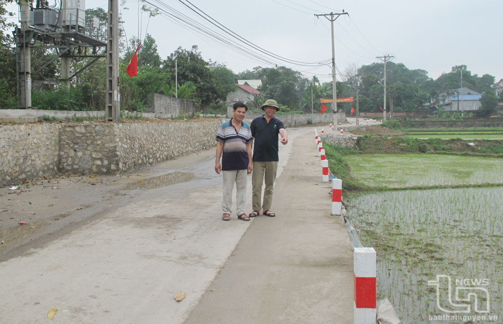 Việc mở rộng tuyến đường xóm Tân Phong, gia đình anh Vi Văn Thiện (người đứng bên trái) gương mẫu hiến 500m2 đất vườn, ruộng để đường mở theo đúng thiết kế.