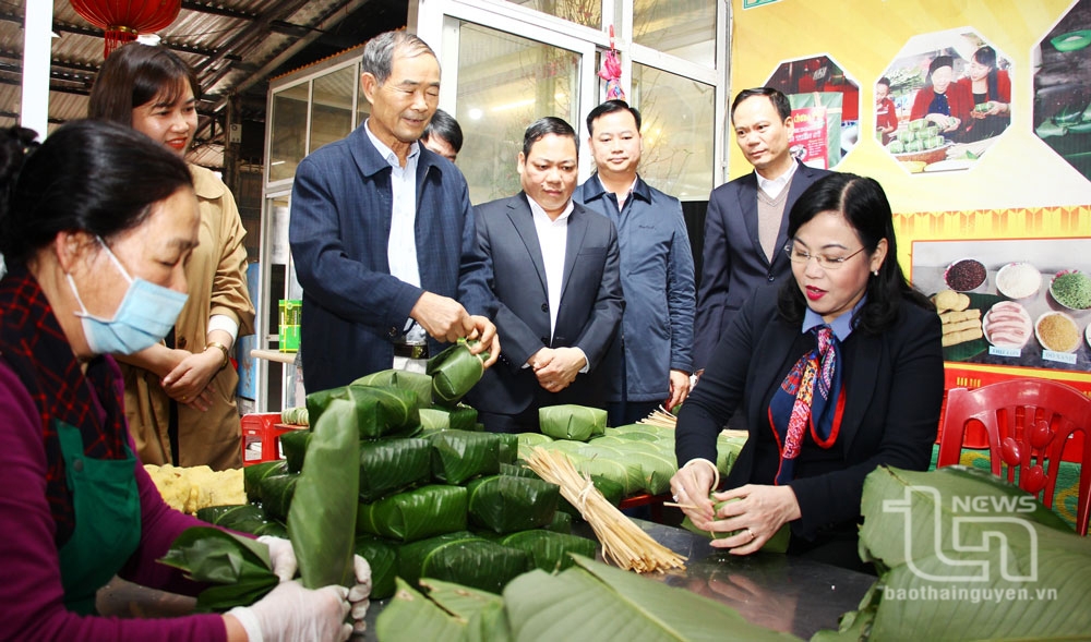 Đồng chí Bí thư Tỉnh ủy Nguyễn Thanh Hải cùng gói bánh chưng với các thành viên Làng nghề bánh chưng Bờ Đậu.