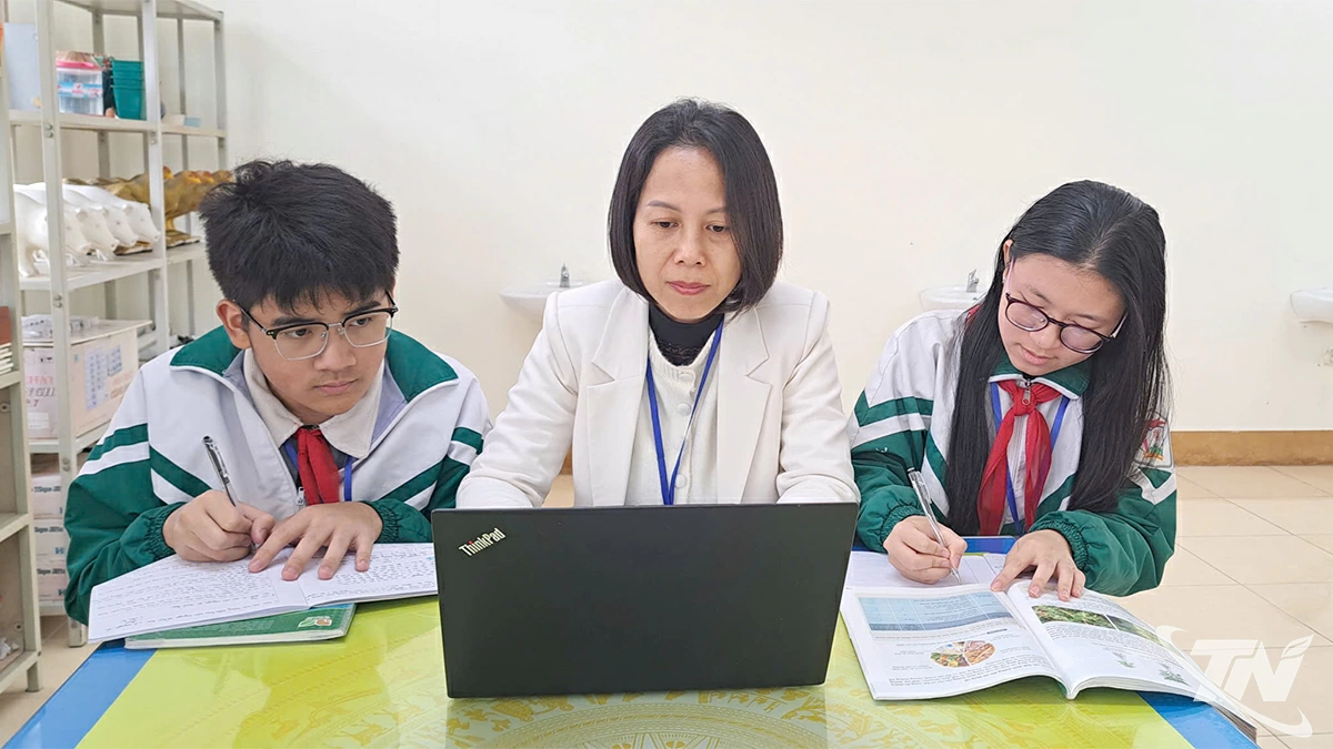 Cô giáo Lăng Thị Liễu Hằng hướng dẫn nhóm học sinh cách trình bày một dự án nghiên cứu.