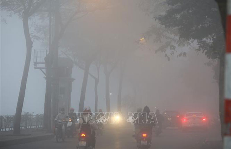 Các tuyến phố nội thành Hà Nội chìm trong làn sương mù dày đặc. Ảnh: Huy Hùng/TTXVN