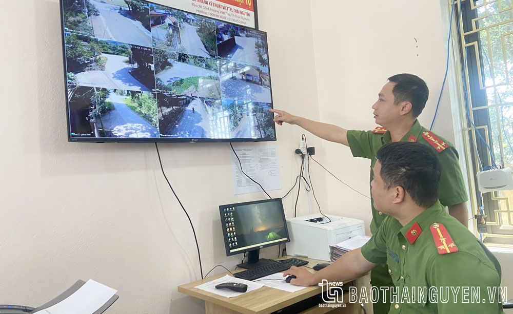 Đại úy Vũ Xuân Huy (người đứng) giám sát tình hình an ninh trật tự qua hệ thống camera an ninh của xã.