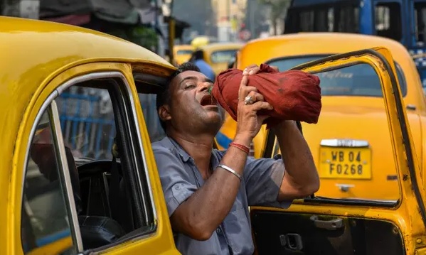 Một người lái xe taxi uống nước trong buổi chiều nóng nực tại Kolkata (Ấn Độ). Ảnh: Shutterstock