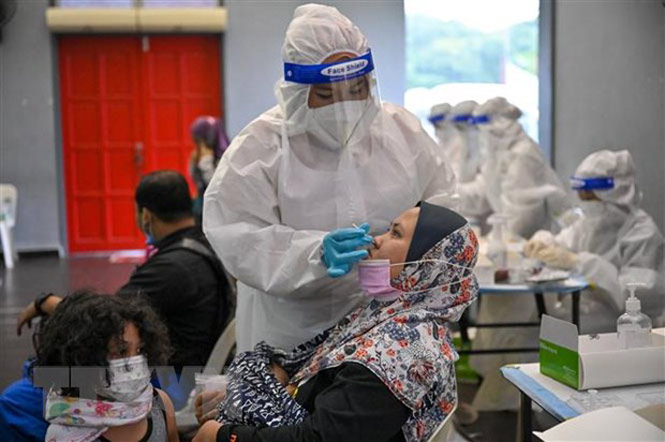 Nhân viên y tế lấy mẫu xét nghiệm COVID-19 cho người dân tại Kuala Lumpur, Malaysia. (Ảnh: AFP/TTXVN)