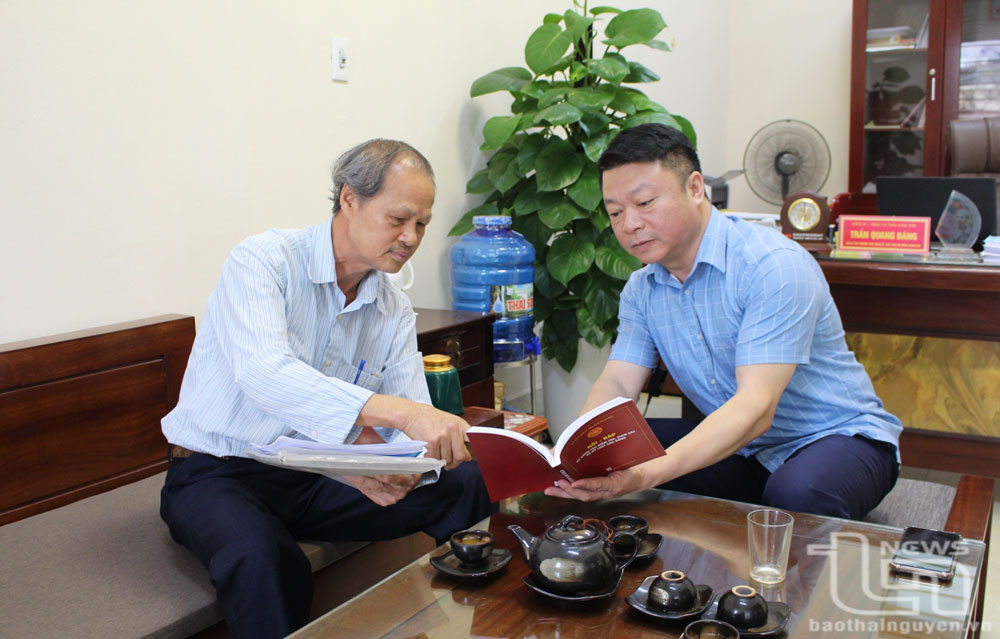 Đồng chí Phó Bí thư Thường trực Đảng ủy thị trấn Hùng Sơn (bên phải) trao đổi với Bí thư chi bộ tổ dân phố Hợp Thành về công tác phát triển Đảng trong vùng đồng bào Công giáo.