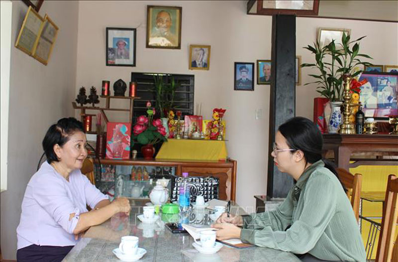 Phóng viên TTXVN trò chuyện với bà Nguyễn Thị Ngọc Bích, em gái liệt sĩ Nguyễn Thị Ngọc Oanh về sự kiện gia đình bà may 2 lá cờ giải phóng trước những năm 1975. Ảnh: Phan Sáu/TTXVN