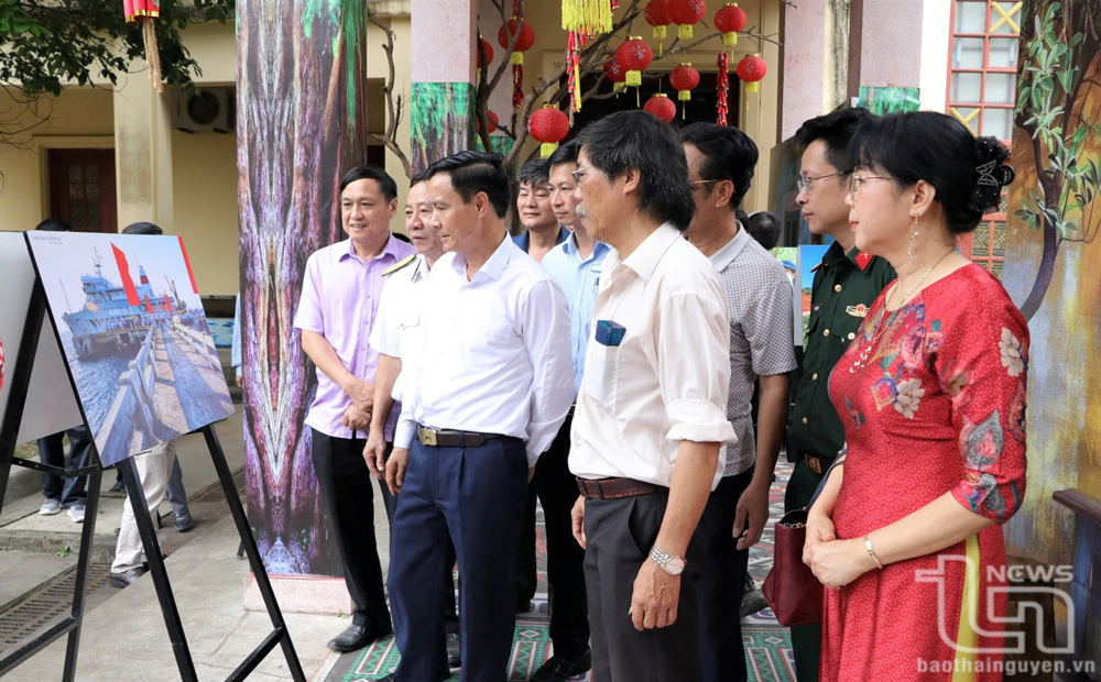 Các đại biểu tham quan triển lãm ảnh.