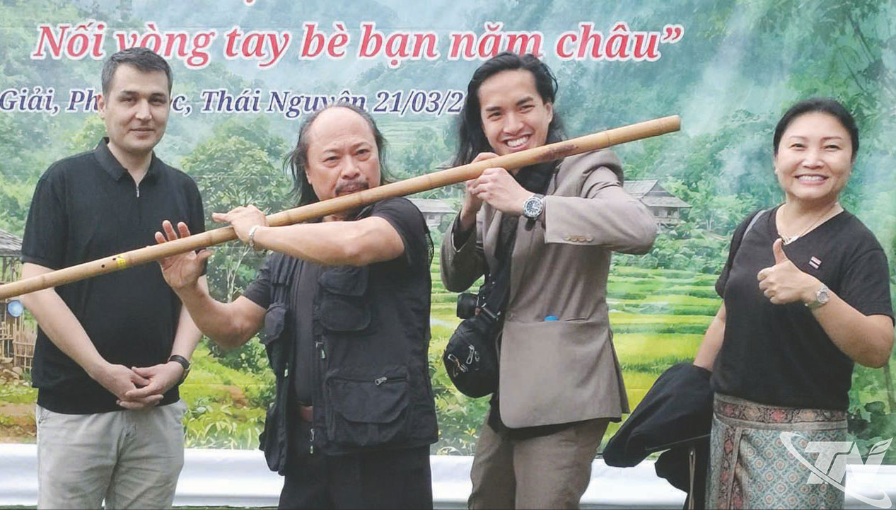 Nghệ sĩ Thanh Lịch (Câu lạc bộ Tâm Giao) hướng dẫn các nhà thơ nước ngoài thổi cây sáo sào dài gần 2m.