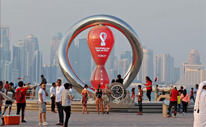 Người dân và du khách chụp ảnh tại điểm đặt đồng hồ đếm ngược tới World Cup 2022 ở Doha, Qatar, ngày 20/10/2022. Ảnh tư liệu: AFP/TTXVN