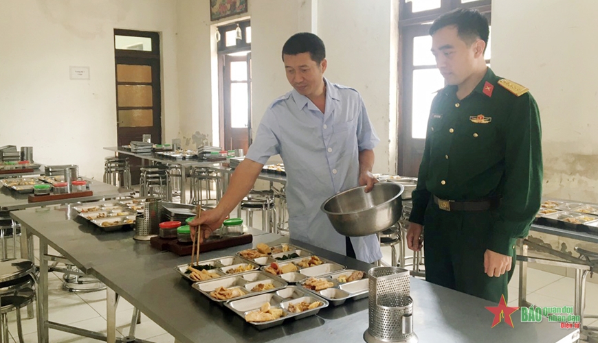 Nhân viên nấu ăn Nguyễn Hữu Toàn chia thức ăn phục vụ bộ đội.