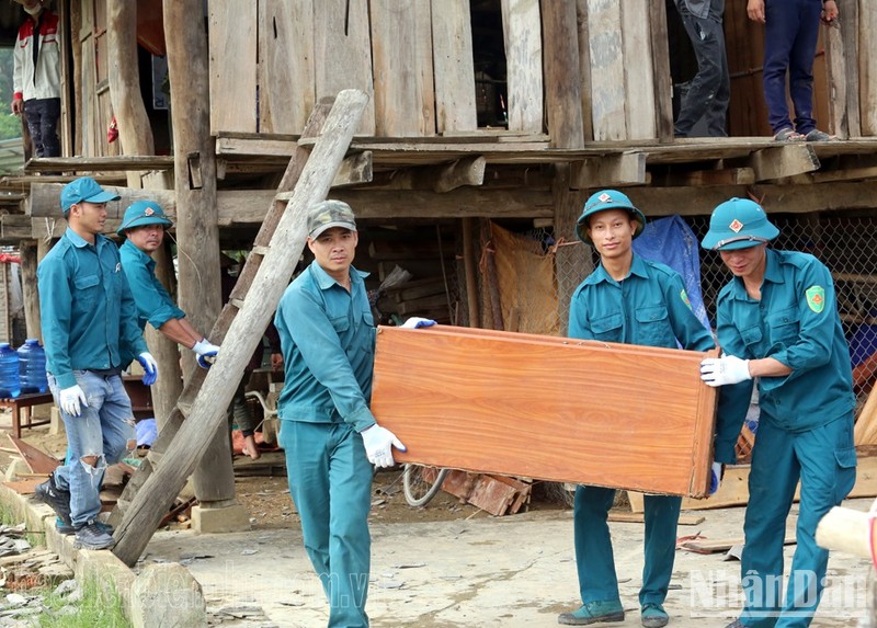 Dân quân xã Thanh Hưng, huyện Điện Biên, hỗ trợ người dân di chuyển tài sản khỏi vùng nguy hiểm. 