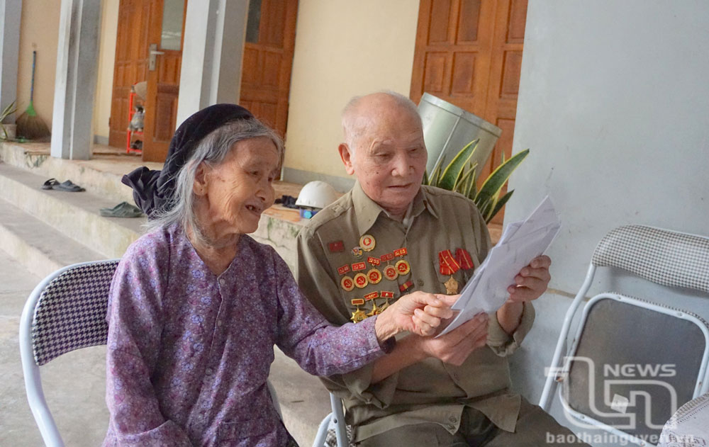 Ông Nguyễn Văn Thúy và vợ xem lại những bức ảnh thăm lại chiến trường Điện Biên xưa.