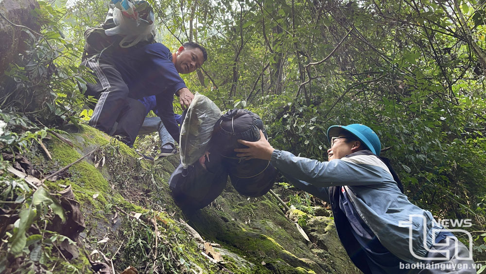 Các thành viên trong đoàn hỗ trợ nhau vận chuyển hành lý qua đoạn đường khó.