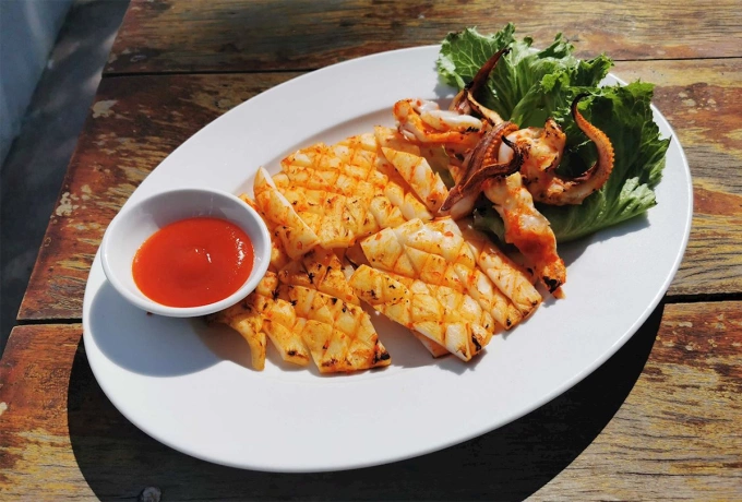 Mực một nắng nướng muối ớt. Ảnh: Taste Atlas
