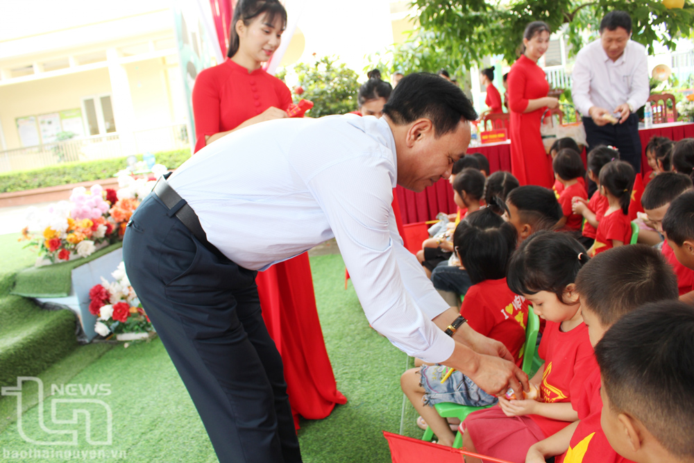 Đồng chí Phạm Văn Thọ phát kẹo cho các cháu thiếu nhi Trường Mầm non Đắc Sơn (TP. Phổ Yên).