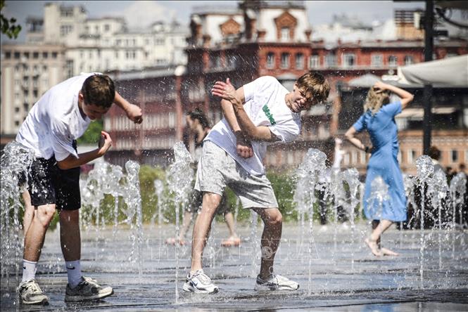 Người dân giải nhiệt tránh nóng tại đài phun nước ở Moskva, Nga ngày 15/6/2023. Ảnh: AFP/TTXVN