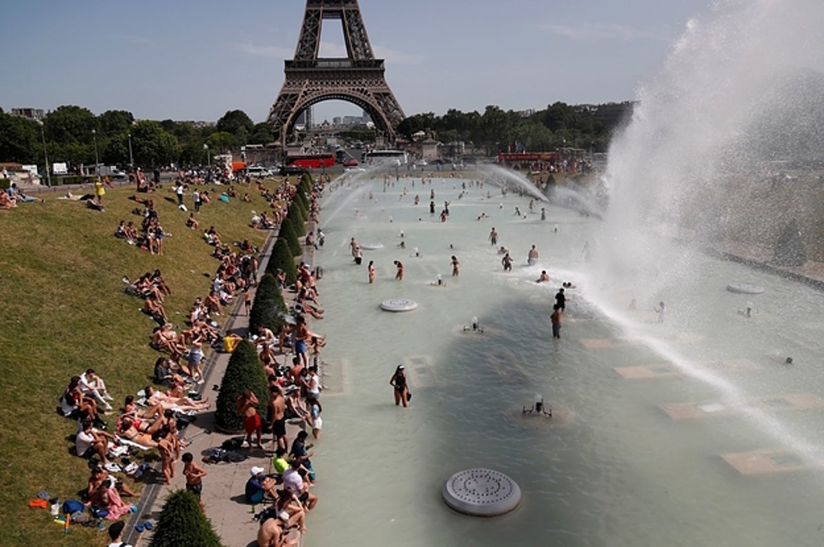 Người dân Paris giải nhiệt trong hồ nước gần Tháp Eiffel trong một ngày nhiệt độ lên tới 40 độ C. Ảnh: AP