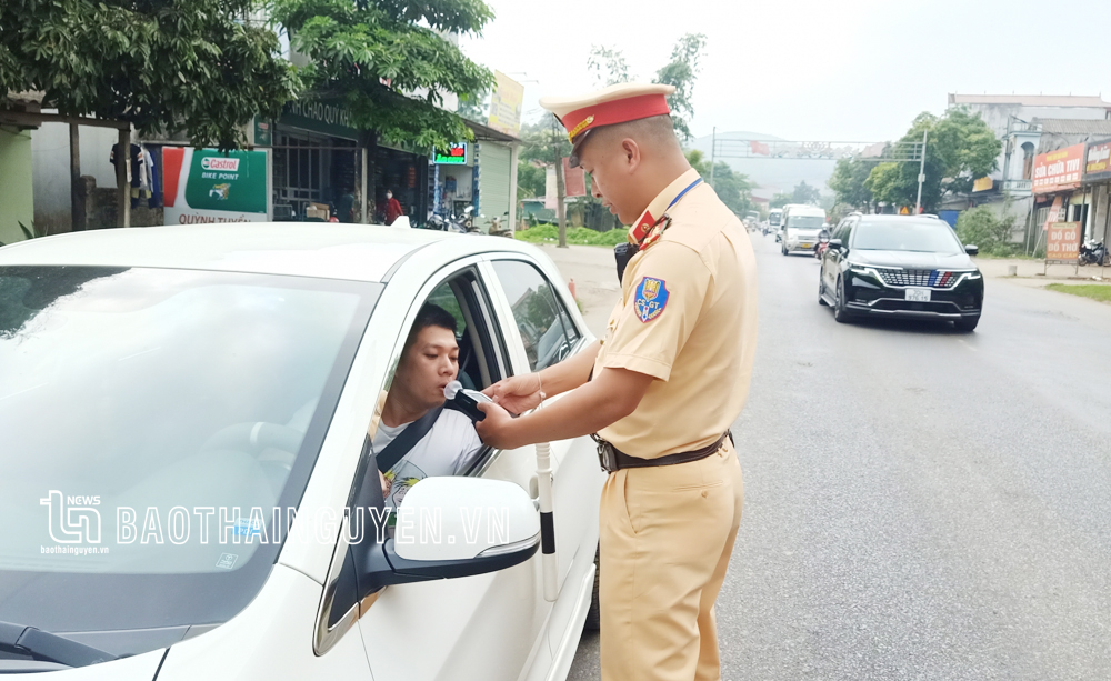Lực lượng Cảnh sát giao thông kiểm tra nồng độ cồn của lái xe ô tô trên Quốc lộ 3 đoạn qua huyện Phú Lương.