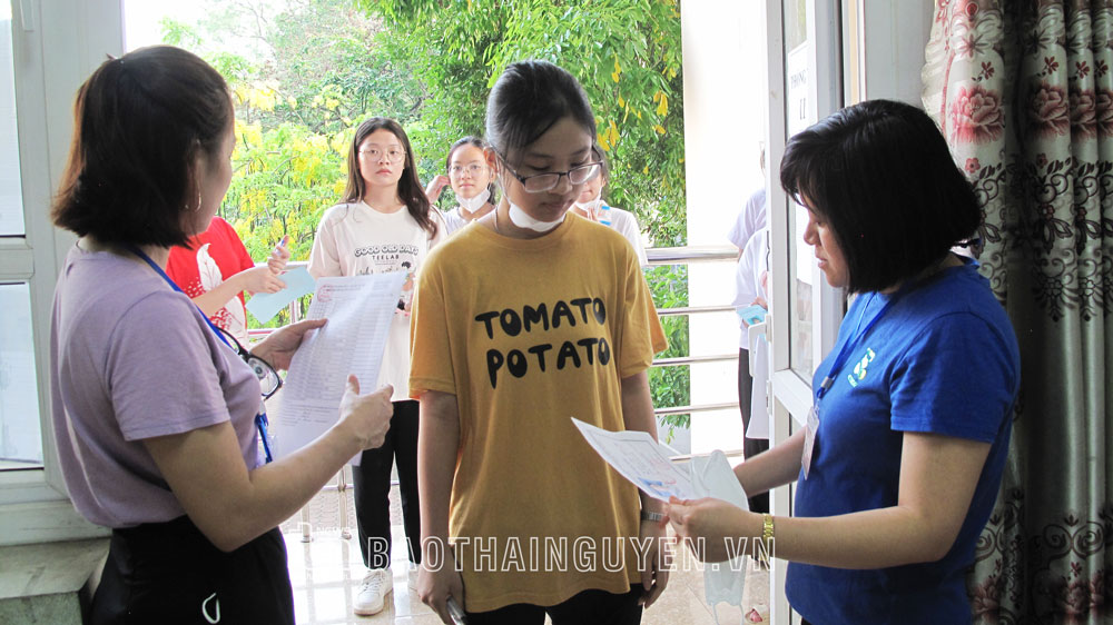 Giám thị đối chiếu ảnh, thông tin thí sinh đăng ký dự thi để phòng chống gian lận trong thi cử tại điểm thi THPT Lương Ngọc Quyến.