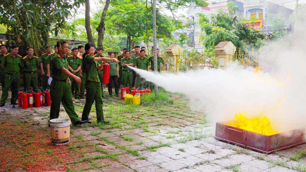 Cán bộ, chiến sĩ Công an thực hành chữa cháy bằng bình bột.