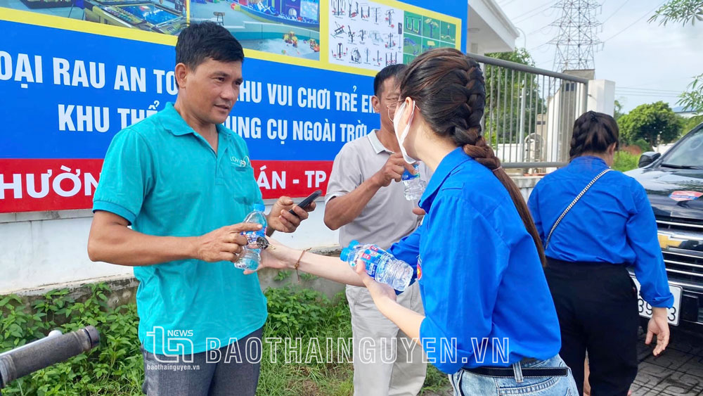 Tình nguyện viên phát nước cho người nhà thí sinh tại điểm thi Trường THPT Ngô Quyền (TP. Thái Nguyên).