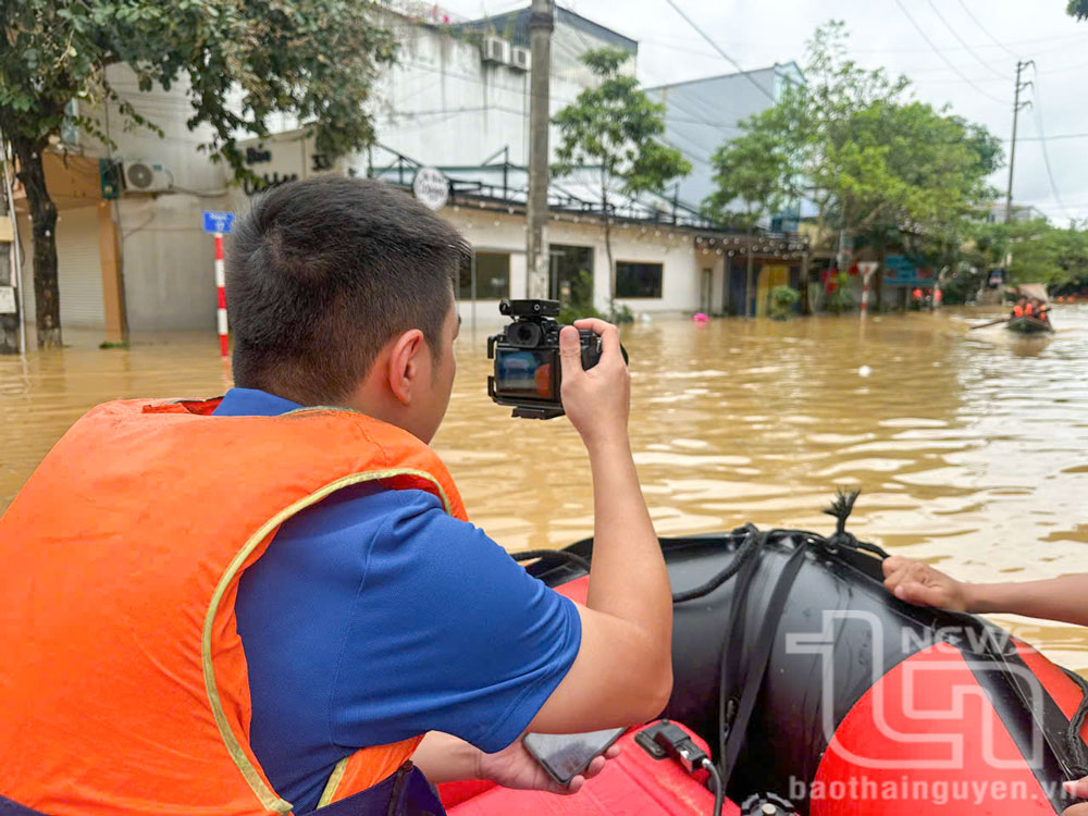 Phóng viên Báo Thái Nguyên tác nghiệp trong vùng lũ.