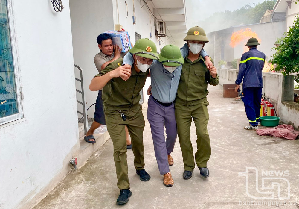 Lực lượng an ninh cơ sở và người dân hỗ trợ đưa người bị mắc kẹt trong đám cháy và tài sản đến nơi an toàn.