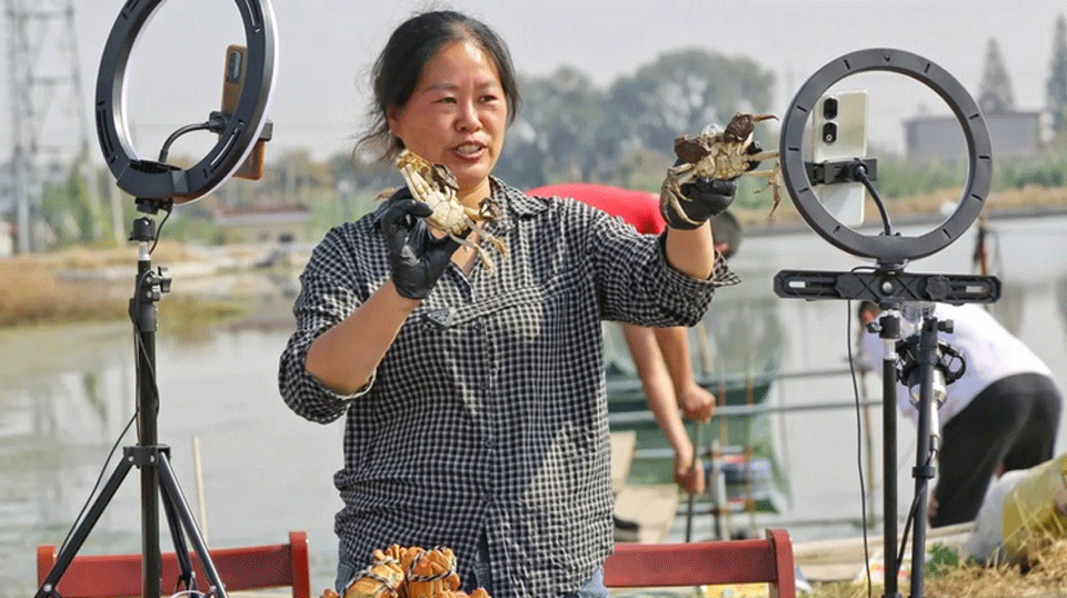 Một người nuôi cua bán cua livestream tại làng Xinhai ở thành phố Haian, tỉnh Giang Tô, Trung Quốc. Ảnh: NurPhoto/Getty Images