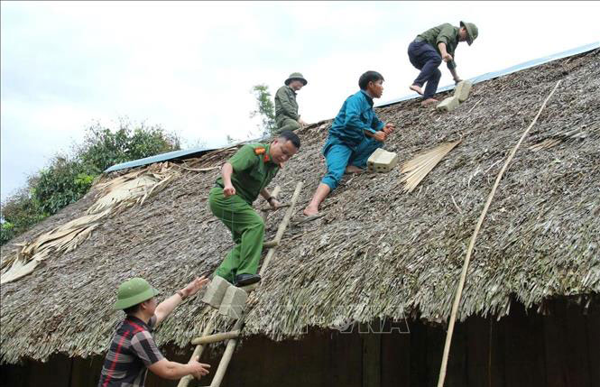 Lực lượng chức năng gia cố mái nhà cho người dân trước bão số 3.