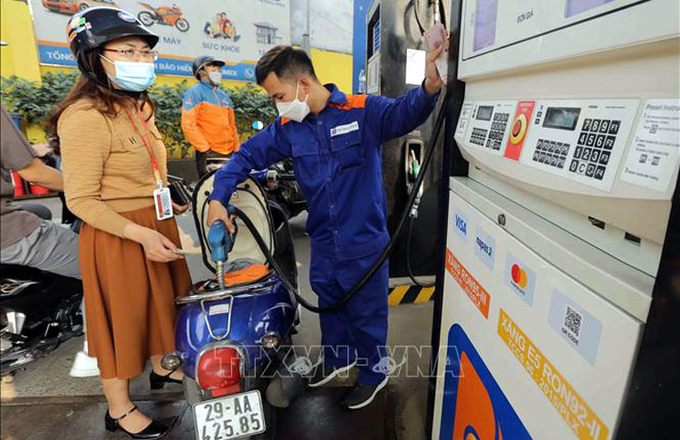 Người dân mua xăng tại cửa hàng xăng dầu. Ảnh: TTXVN
