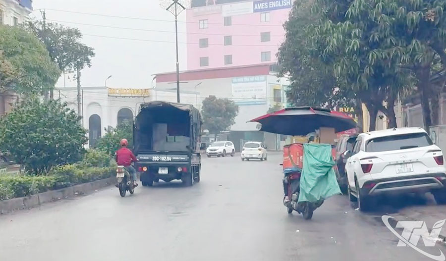 Xe máy gắn ô lưu thông trên đường Bắc Sơn, phường Phan Đình Phùng.