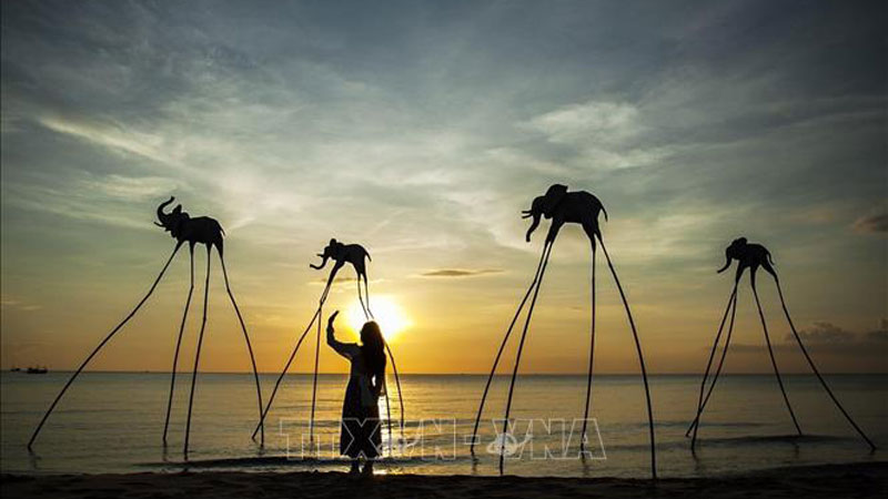 Du khách trải nghiệm không gian hoàng hôn trên Bãi Trường, nơi được cho là địa điểm ngắm hoàng hôn đẹp nhất Việt Nam. Ảnh: Hồng Đạt/TTXVN