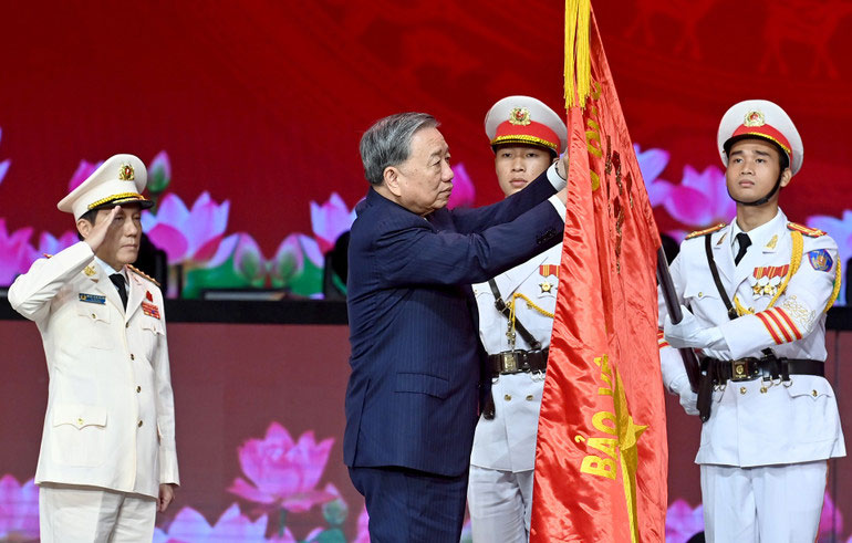 Tổng Bí thư Tô Lâm gắn Huân chương Sao Vàng lên lá cờ truyền thống của Lực lượng Công an nhân dân Việt Nam. (Ảnh ĐĂNG KHOA)