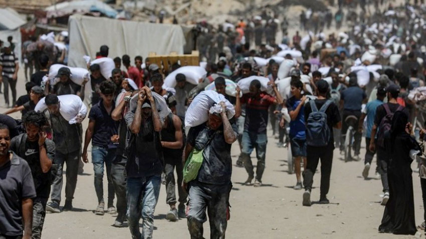 Người dân Palestine nhận hàng viện trợ nhân đạo tại Beit Lahia, phía Bắc Dải Gaza, ngày 1/8/2025. (Ảnh: THX/TTXVN)