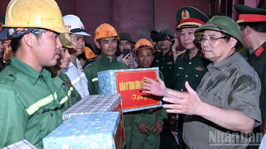 Thủ tướng Phạm Minh Chính tặng quà đội thi công của Tổng công ty Xây dựng Trường Sơn đang khẩn trương thi công hạng mục chuẩn bị cho hợp long cầu Phong Châu những ngày tới.