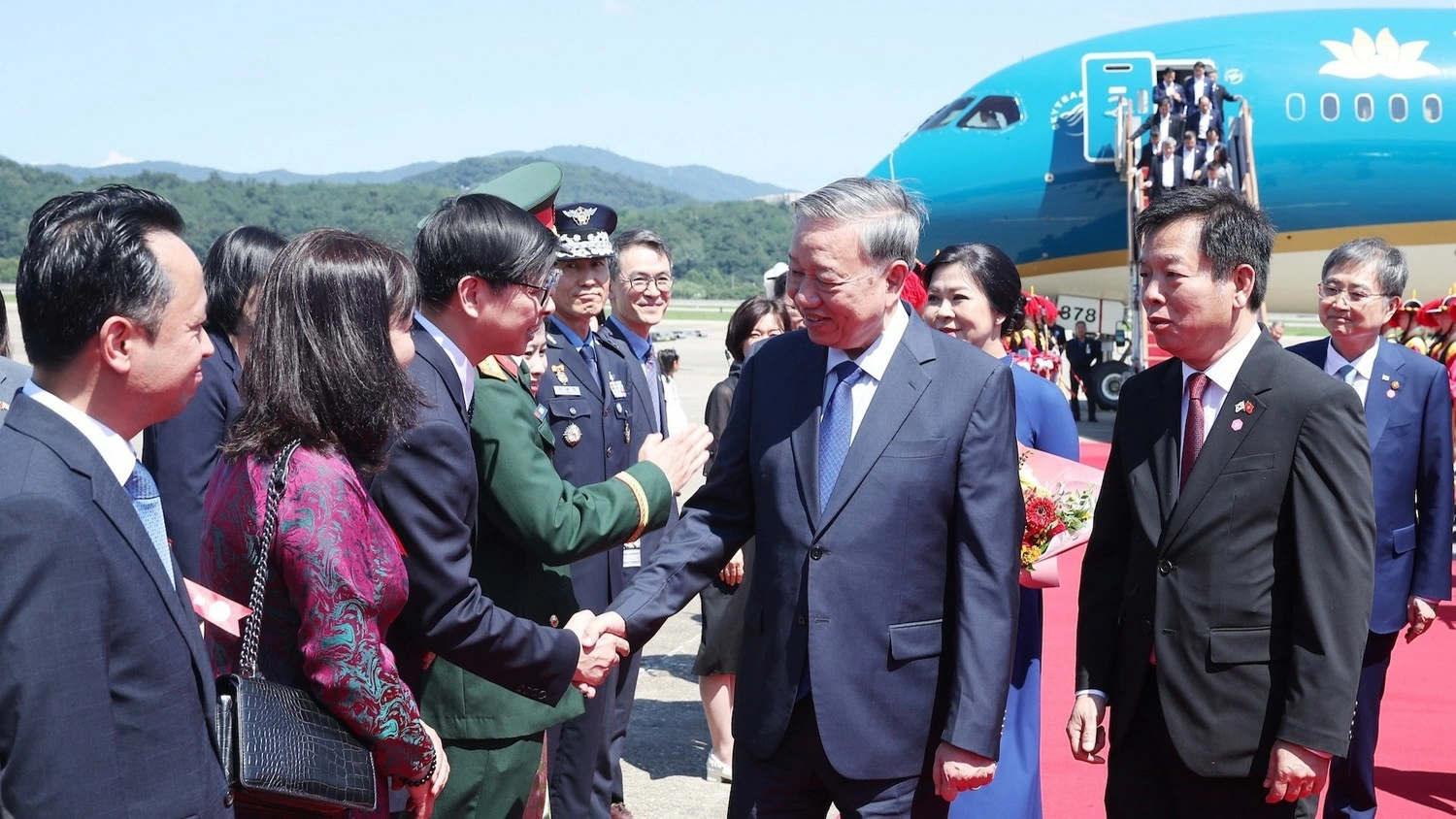 Cán bộ, nhân viên Đại sứ quán và cộng đồng người Việt Nam tại Hàn Quốc đón Tổng Bí thư Tô Lâm và Phu nhân ở Sân bay quân sự Seongnam. Ảnh: Thống Nhất/TTXVN