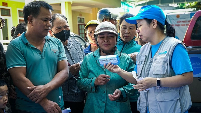 Cán bộ của UNICEF với người dân ở vùng bị ảnh hưởng bởi lũ lụt, sạt lở đất do hoàn lưu của bão số 3. (Ảnh UNICEF)