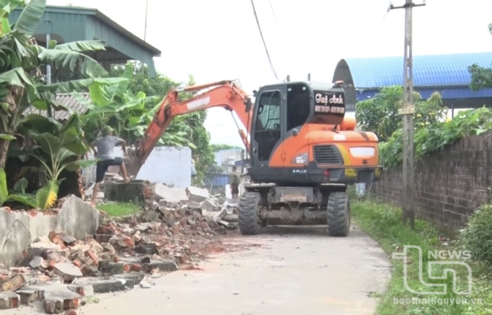 Người dân tổ dân phố Gò Vầu, thị trấn Hùng Sơn, dỡ tường rào, hiến đất mở rộng đường giao thông.