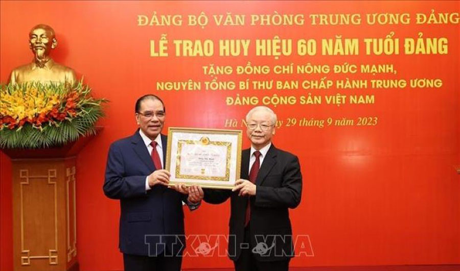 Tổng Bí thư Nguyễn Phú Trọng trao Huy hiệu 60 năm tuổi Đảng cho nguyên Tổng Bí thư Nông Đức Mạnh. (Ảnh: TTXVN)