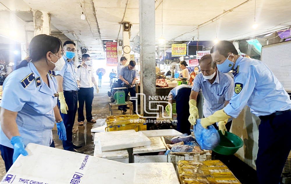 Lực lượng chức năng tiến hành kiểm tra quầy hàng kinh doanh kinh doanh thịt lợn của bà Nguyễn Thị Quy.